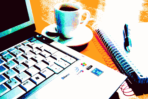 laptop, tasse und block auf tisch